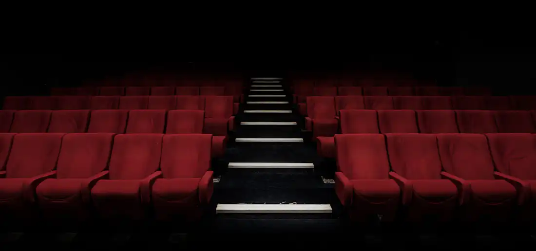 Butacas vacías de una sala de cine en penumbra