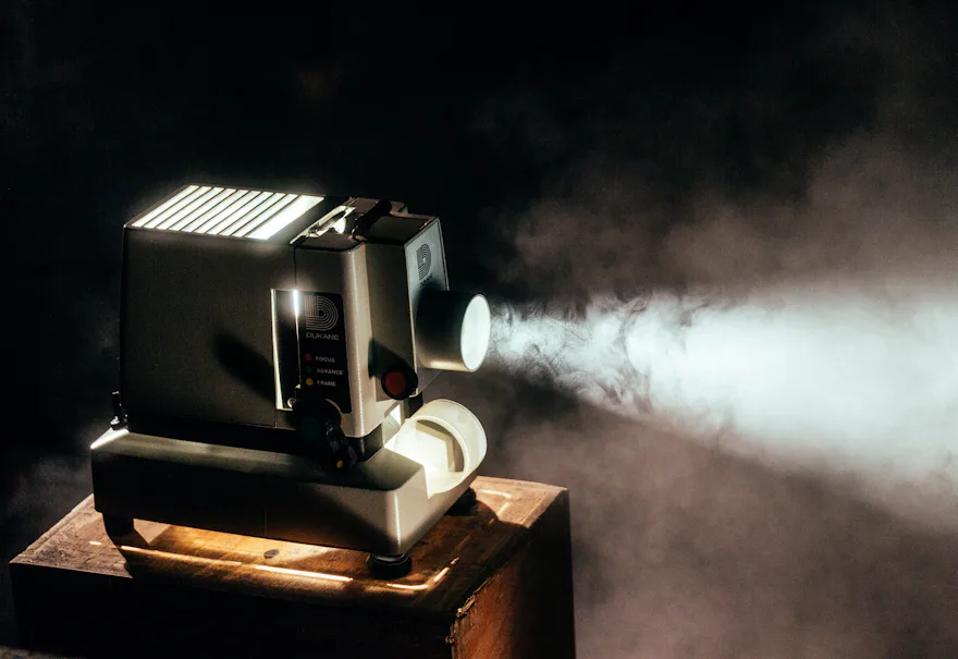 Proyector antiguo lanzando un haz de luz en la oscuridad